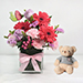 Lovely Mixed Flowers In Glass Vase With Teddy